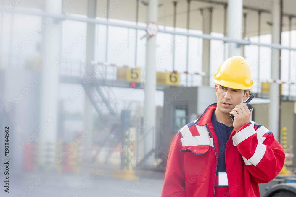 Male worker using walkie-talkie in shipping yard Male worker using walkie-talkie in shipping yard