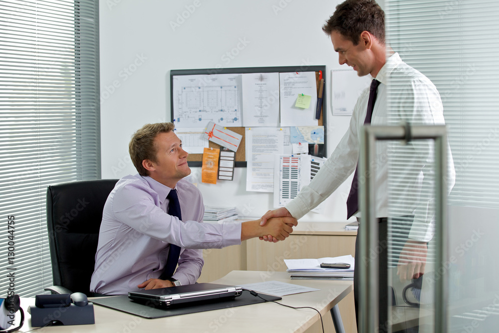 Two businessman shaking hands at office Two businessman shaking hands at office
