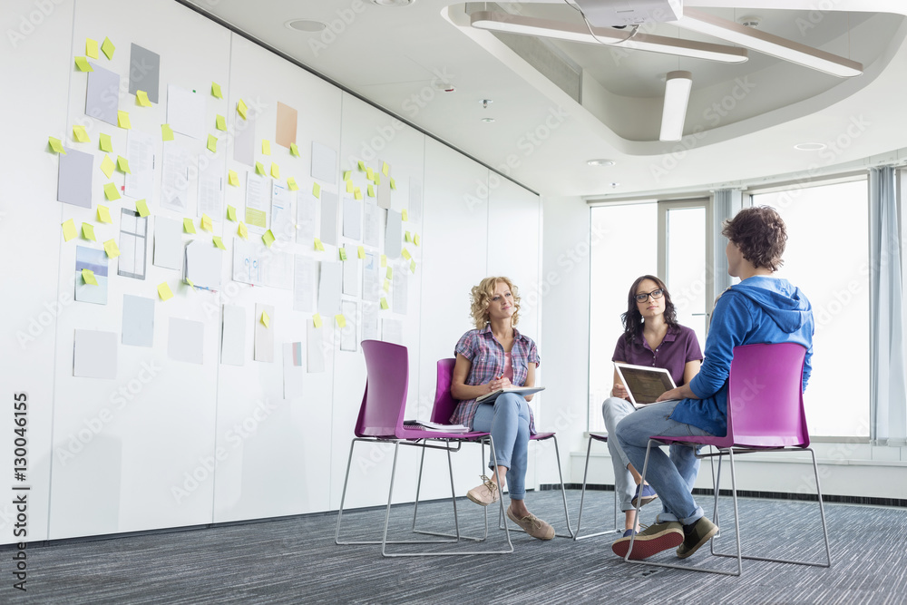 Businesspeople discussing in creative office space Businesspeople discussing in creative office space