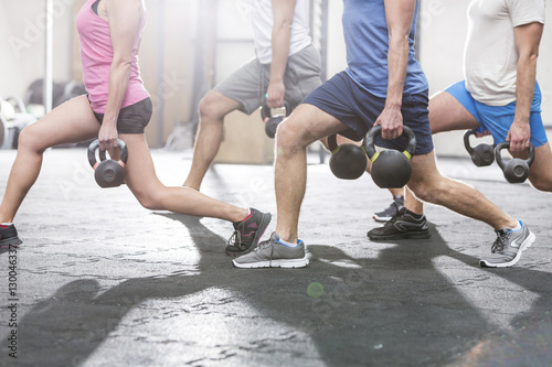 Papier peint Low section of people lifting kettlebells at crossfit gym
