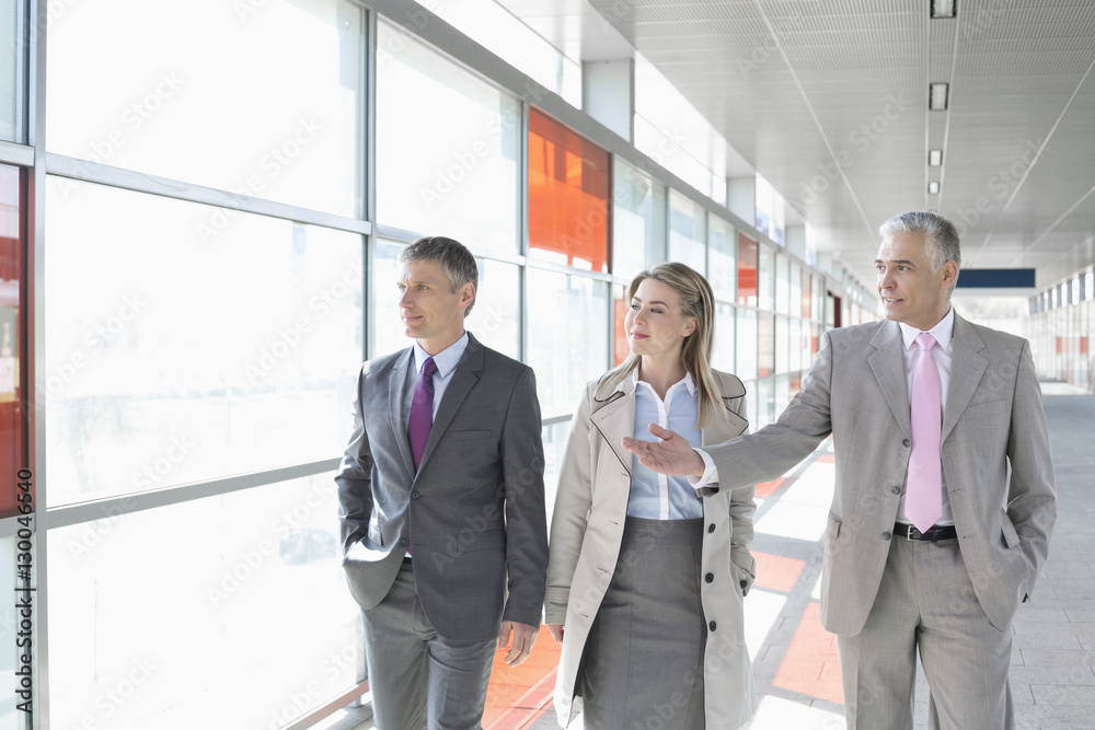 Business colleagues walking on train platform