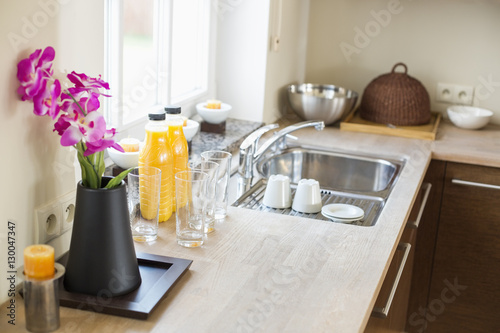 Flower vase with juice bottles on kitchen counter