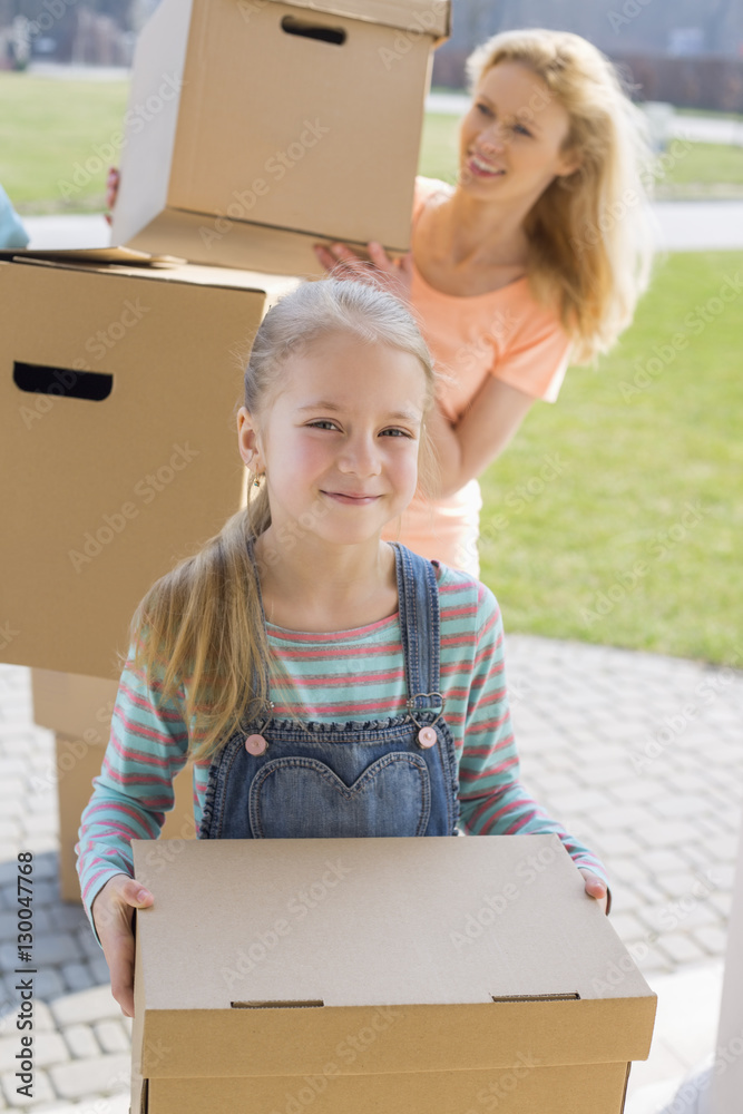 Mother and daughter with cardboard boxes moving into new house Mother and daughter with cardboard boxes moving into new house
