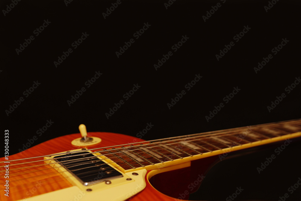 Fototapeta premium Vintage electric guitar closeup on the black background, with plenty of copy space. Selective focus.