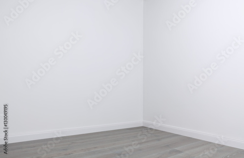 White walls and wooden flooring in the corner of empty room photo