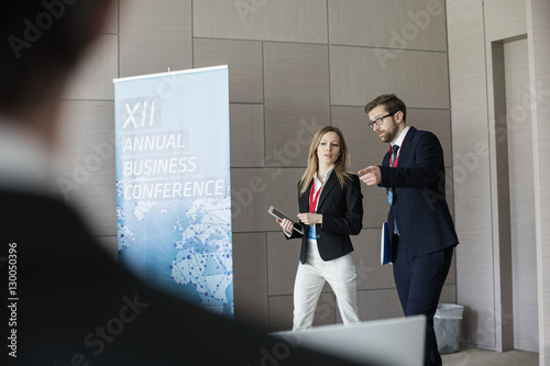 Fotografie Confident business people discussing while walking in convention center