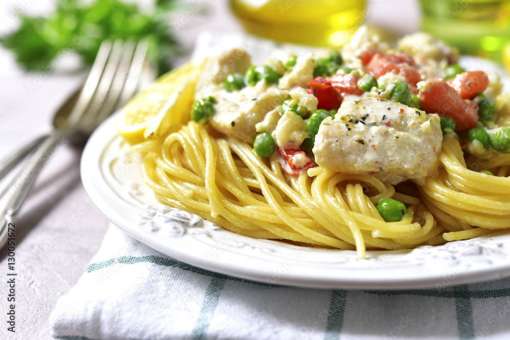 Codfish in a cream sauce with vegetables garnished with spaghett Codfish in a cream sauce with vegetables garnished with spaghett