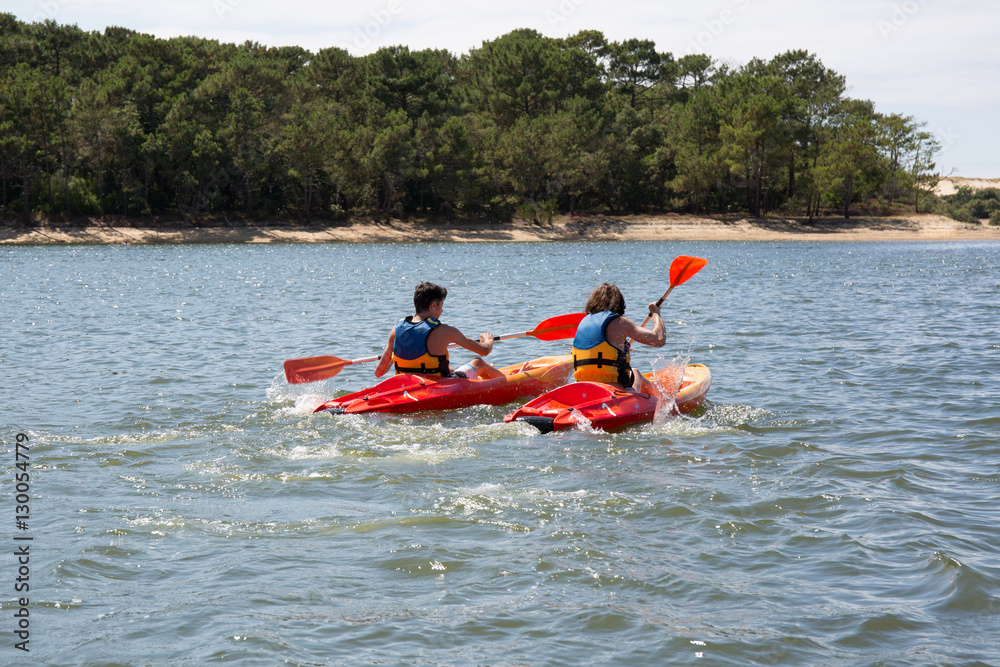 a couple have fun in river by making race with location kayak