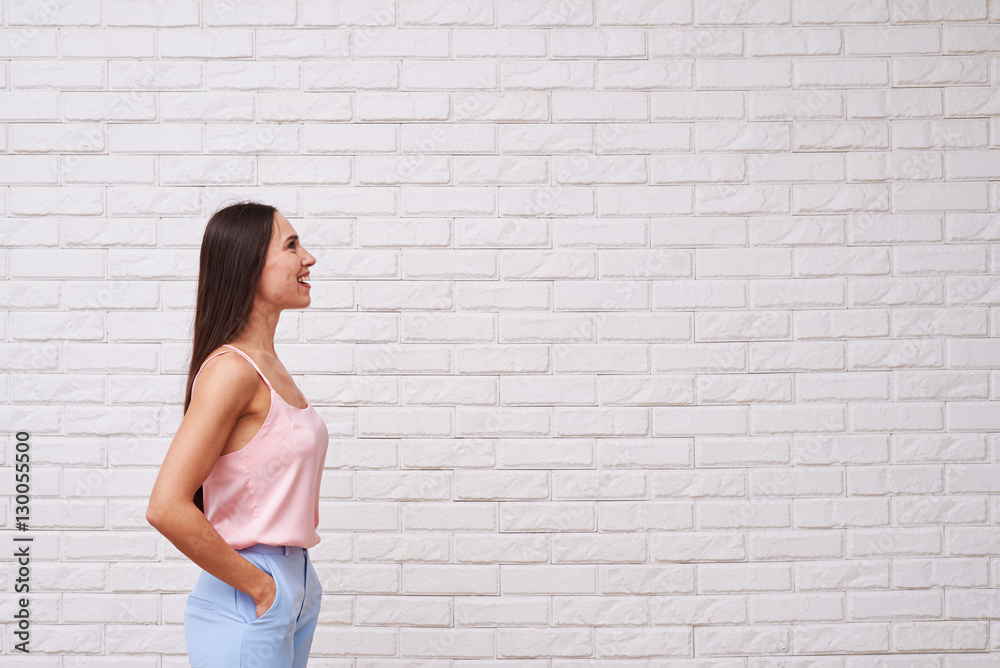Mid side view of pensive brunette looking up and smiling over wh Mid side view of pensive brunette looking up and smiling over wh