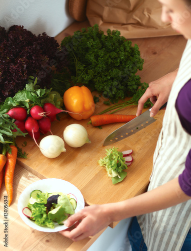 Young woman cutting vegetables in the kitchen