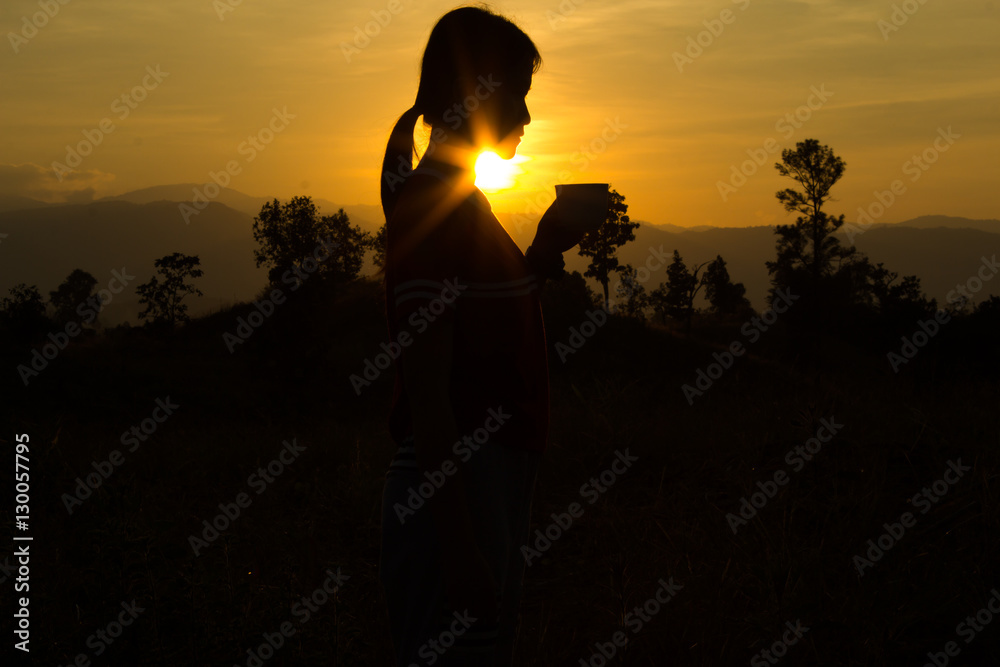 Woman  drinking cup of hot tea or coffee outdoors in sunlight