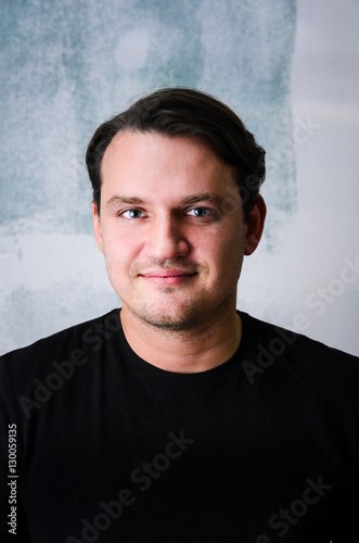 Portrait of young adult happy man agaist grunge wall © Sergey Peterman