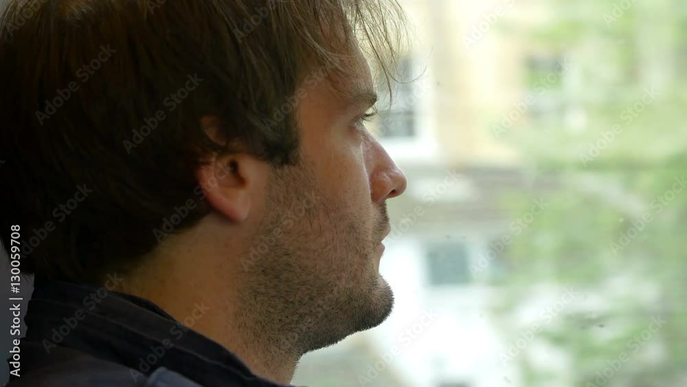 sitting on the train and travelling: young pensive man looking out the window sitting on the train and travelling: young pensive man looking out the window