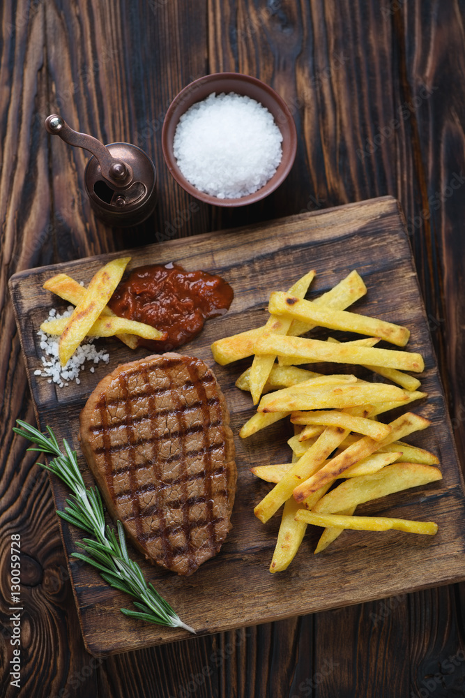 Grilled beef medallion with potato in a rustic wooden setting Grilled beef medallion with potato in a rustic wooden setting