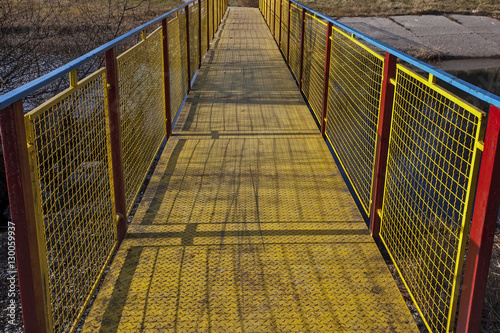 Metal bridge painted in vivid blue, yellow and red