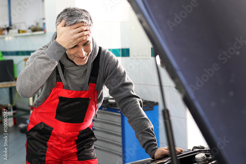 Naprawa samochodu, mężczyzna w pracy. Mechanik samochodowy pracuje w warsztacie 