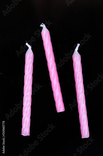 Assorted colored candles isolated on black background
