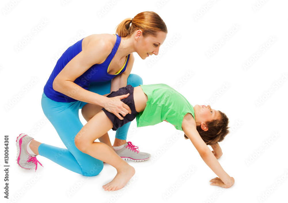 Mother helping her kid son making a crab posture Mother helping her kid son making a crab posture