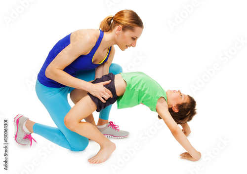 Mother helping her kid son making a crab posture