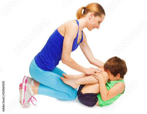 Mother teaching her kid son making gymnastics