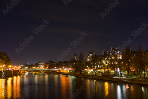 Bridge by the Seine river with view on the Hotel de ville in Paris at night