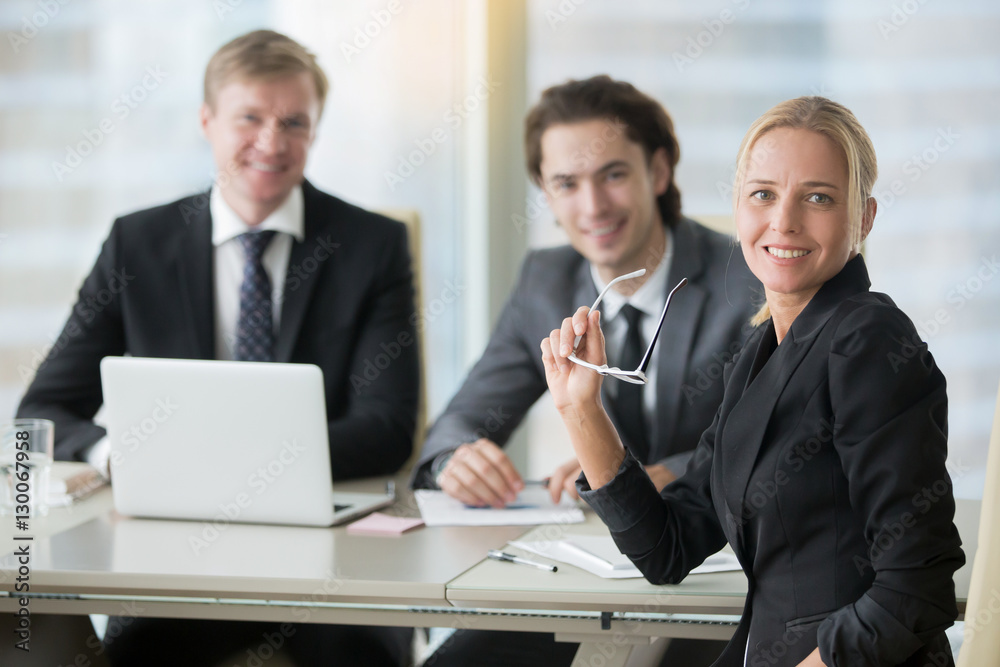 Group of smiling businessmen at the modern office desk Group of smiling businessmen at the modern office desk
