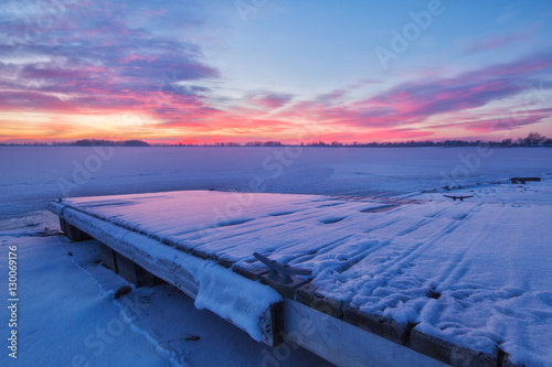 Winter Sunrise on a Snow covered Lake and Fishing Dock