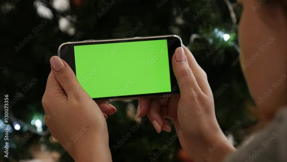 Planning on green screen display phone at New Year night celebration 4K 2160p 30fps UltraHD footage - Woman holds greenscreen tablet in front of Christmas tree 3840X2160 UHD video Planning on green screen display phone at New Year night celebration 4K 2160p 30fps UltraHD footage - Woman holds greenscreen tablet in front of Christmas tree 3840X2160 UHD video