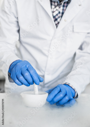 Chemist performs an experiment with liquid nitrogen © guruXOX