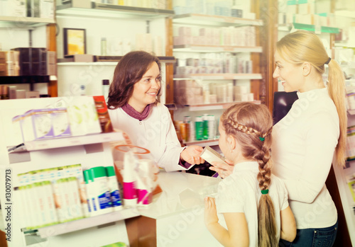 Happy woman pharmacist helping customers