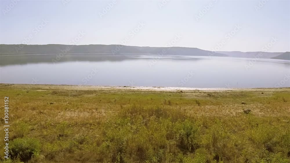 Aerial. Over coast of lake to surface
Aerial. Over coast of lake to surface