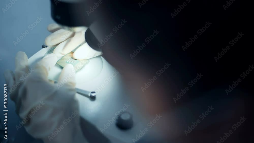 Professional scientist holding and observing the micro chip.