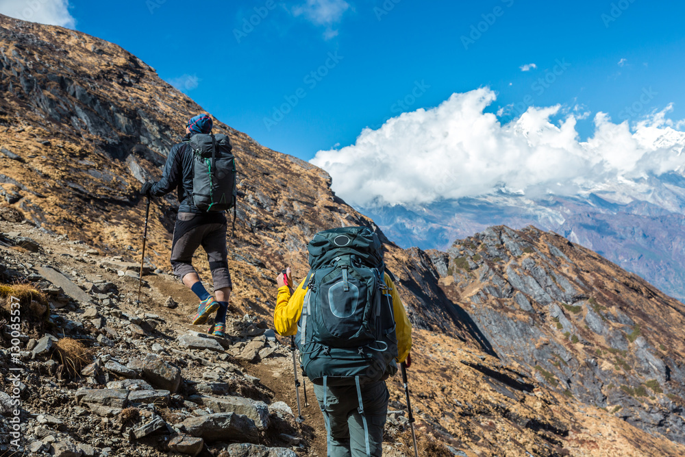 Two Hikers with Backpacks walking up on Mountain Trail