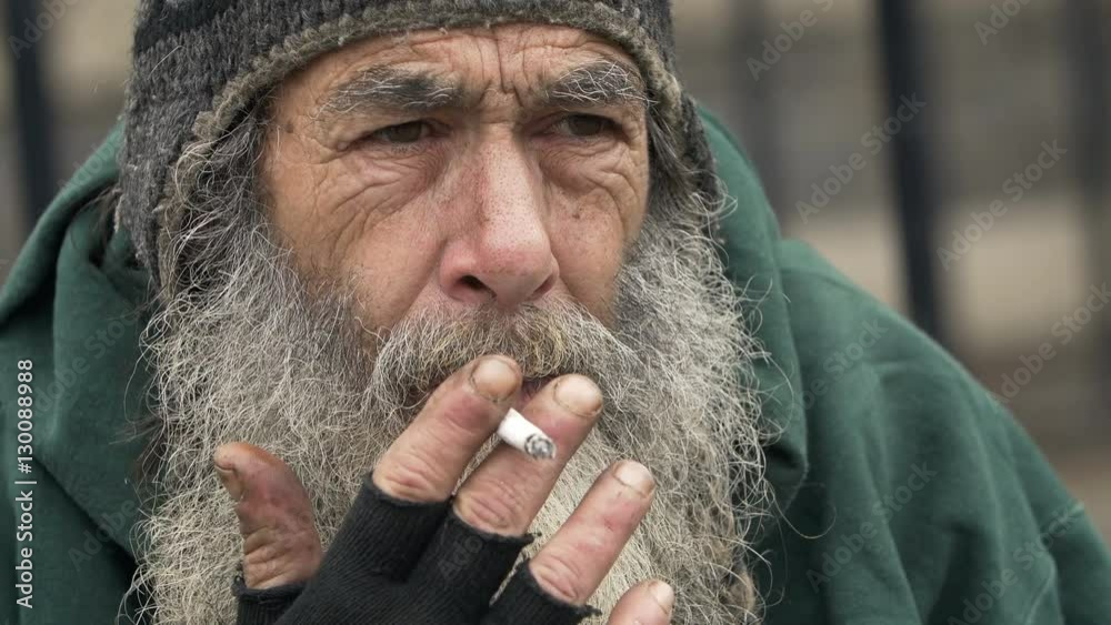 sad and lonely old man smoking: closeup footage of homeless man