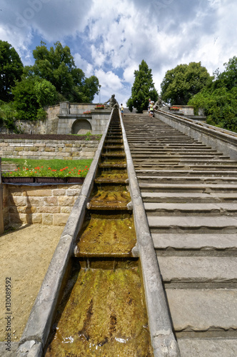 Slope built of stone with a step waterfall seen beside it