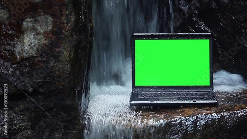 Laptop green screen in waterfall photo