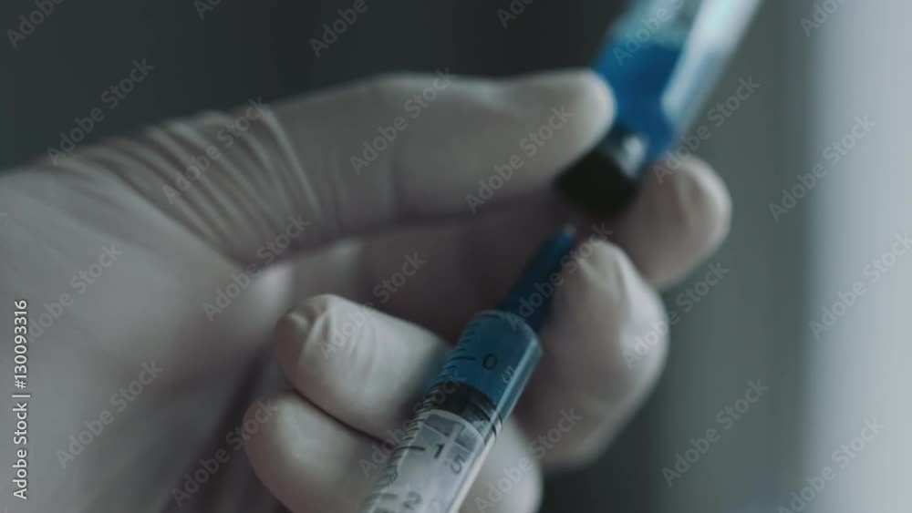 Doctor preparing a syringe for injection. Close-up shot Doctor preparing a syringe for injection. Close-up shot