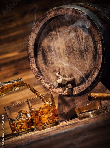 Fotografie Glasses of whiskey with ice cubes served on wood