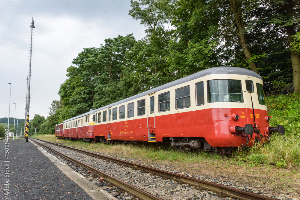 A red and cream train stationed beside the track