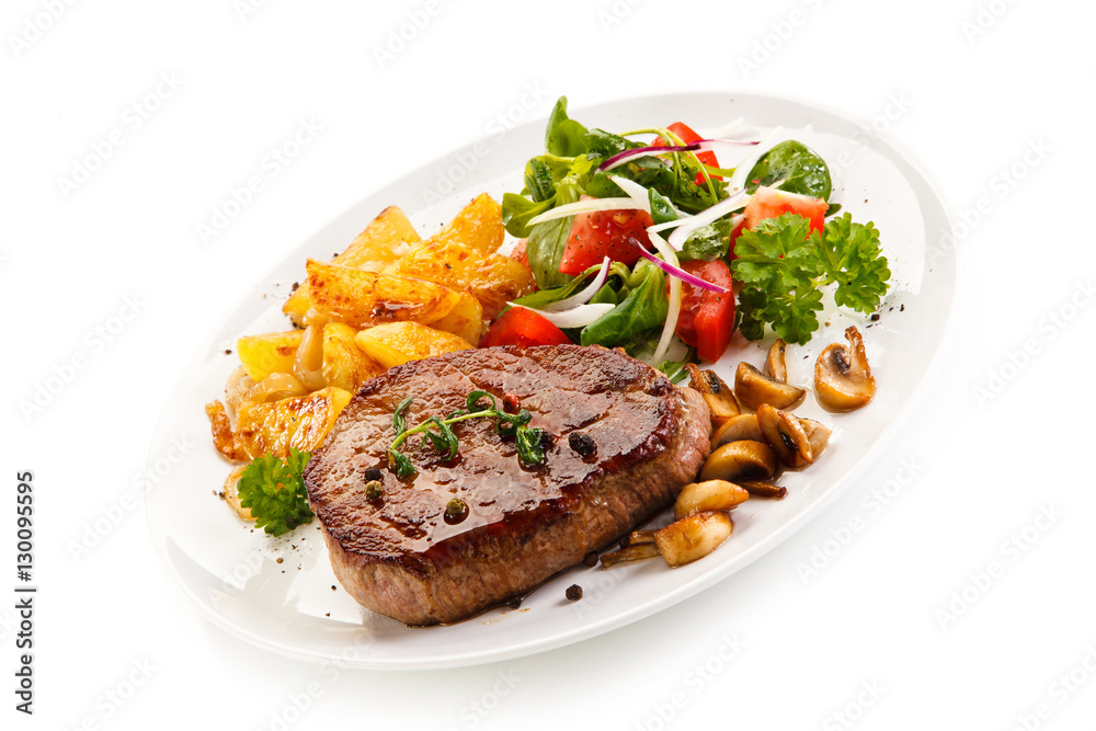 Grilled steak, baked potatoes and vegetable salad on white background 