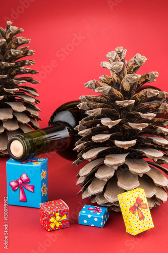 Wine bottle, pincone and colorful Christmas gift boxes photo