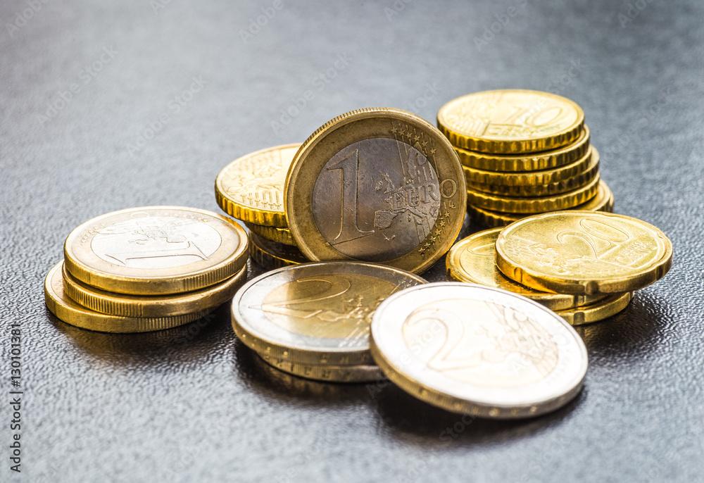 Euro coins. One Euro coin on the foreground. Euro coins. One Euro coin on the foreground.