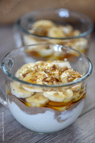 Granola with yogurt, bananas and whole walnuts, maple syrup clea