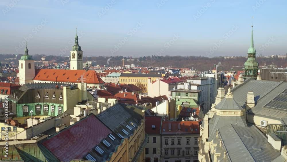 Tiled roofs and gothic spires of old town of Prague on a sunny day, Czech Republic. 4K overview pan shot