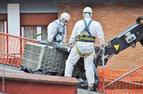 Trabajadores de amianto retiran tejado de fibrocemento con una grúa, en Mondragon (Guipuzcoa)