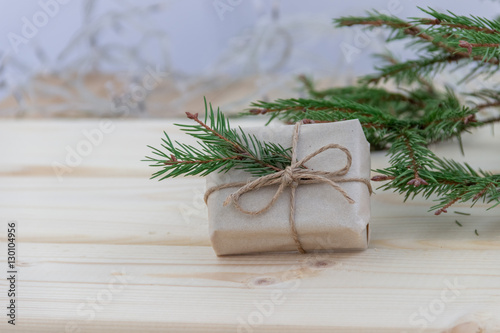 Копозиция с еловой веткой , поздравлением и подарком к Рождеству и Новому году на деревянном фоне. Концепция международные празднования.
