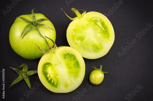 Green tomatoes on dark backgeround photo