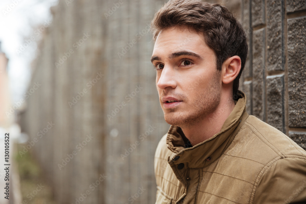 Attractive young man walking on the street and looking aside. Attractive young man walking on the street and looking aside.