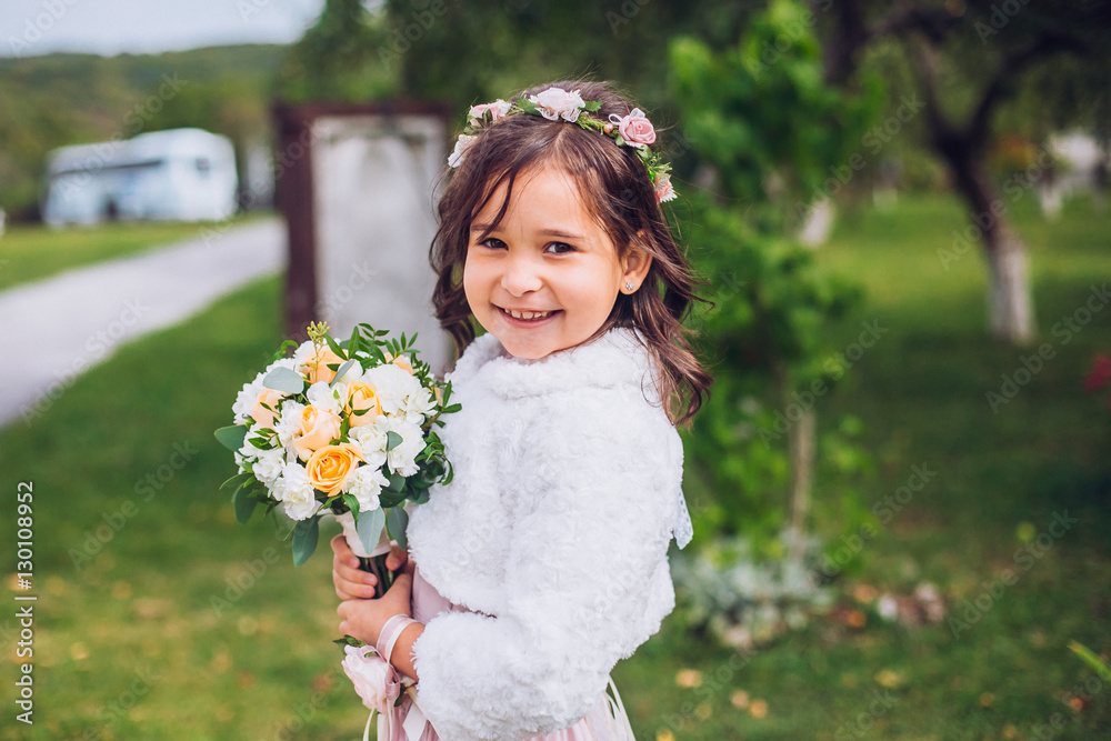 Bride with bridesmaids and little girl kids in the same color dress posing on camera in the park on the wedding day Bride with bridesmaids and little girl kids in the same color dress posing on camera in the park on the wedding day