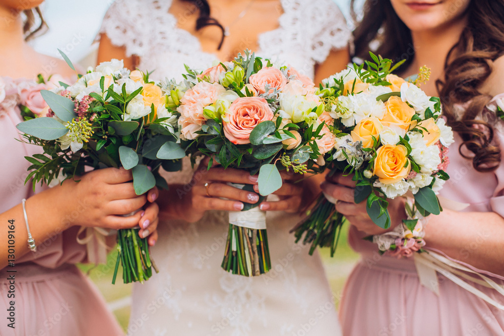 Bride with beautiful bridesmaids in lilac color dresses holding bouquets. Autumn in the Park. Sunny day. Close up. Copy space.